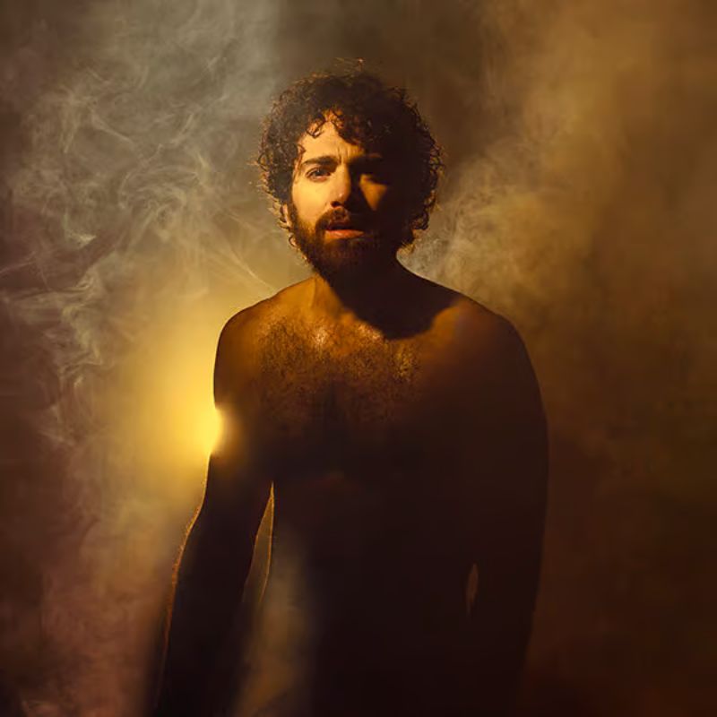 Hombre con luz detrás y humo alrededor