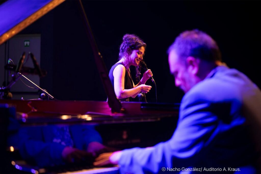 Cantante y pianista actuando en escenario iluminado
