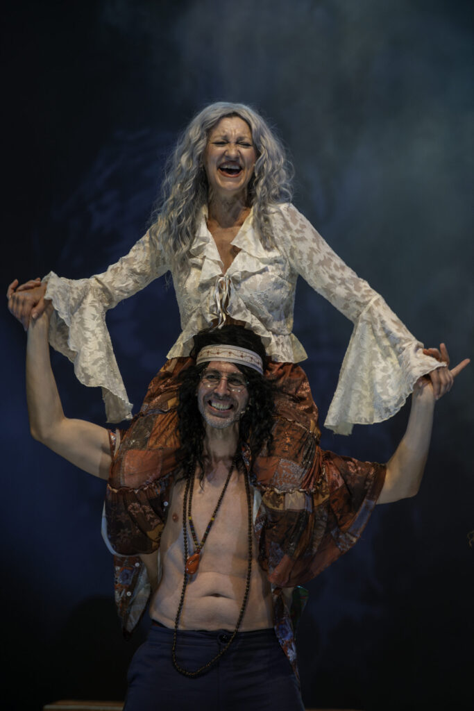 Pareja sonriendo en escena teatral colorida.