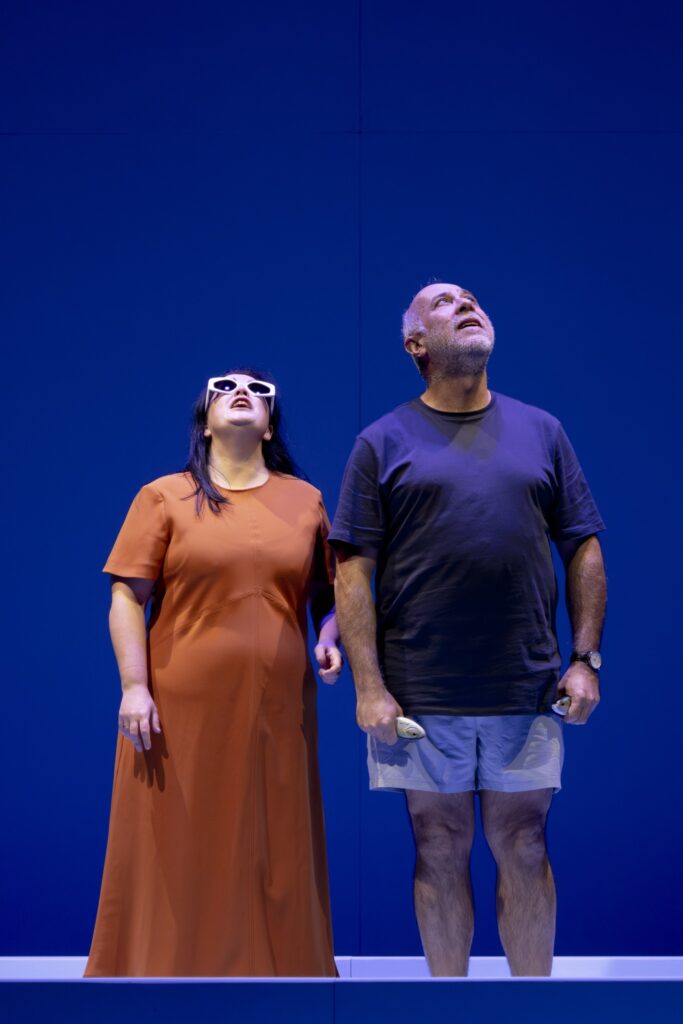 Dos personas mirando al techo, fondo azul.