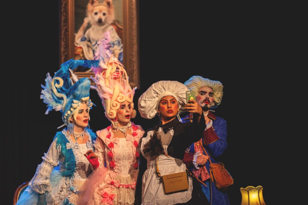 Personas disfrazadas sacándose selfie en teatro.