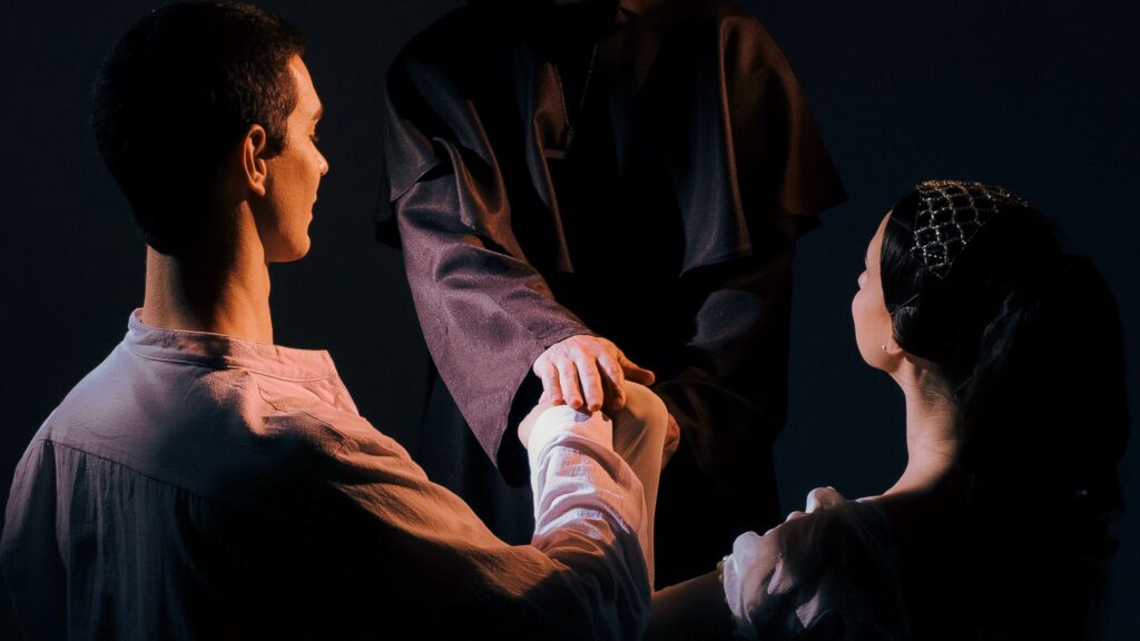 Pareja recibiendo bendición de religioso en escena teatral.