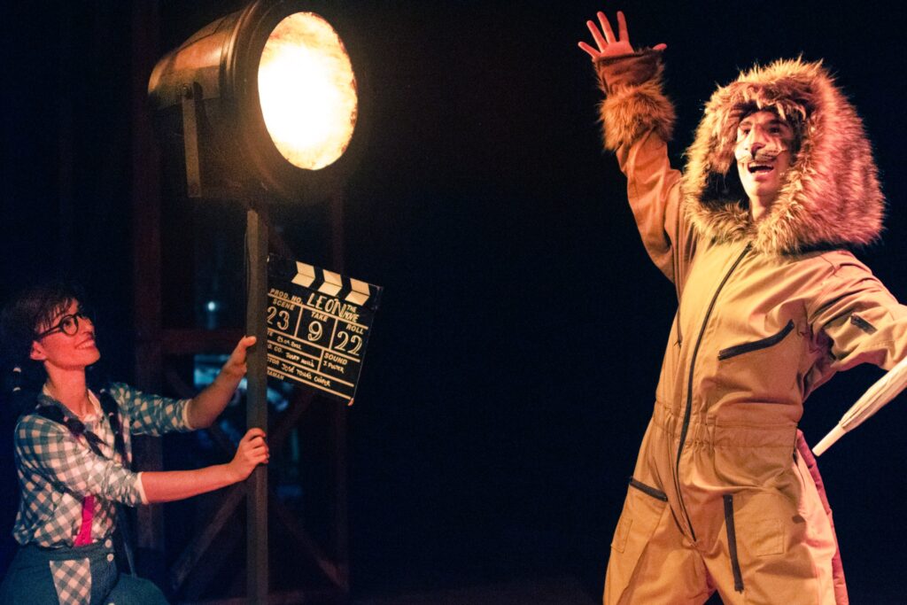 Personaje disfrazado de león en escena teatral.