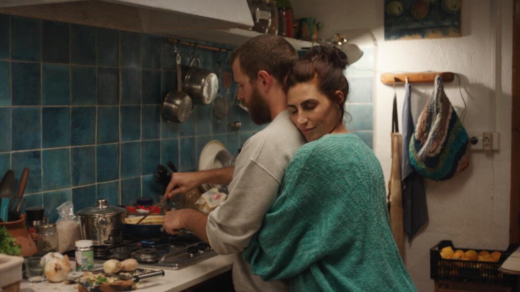 Pareja cocinando juntos en cocina acogedora.