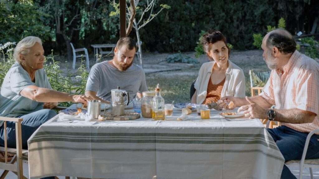 Familia disfrutando comida al aire libre en jardín