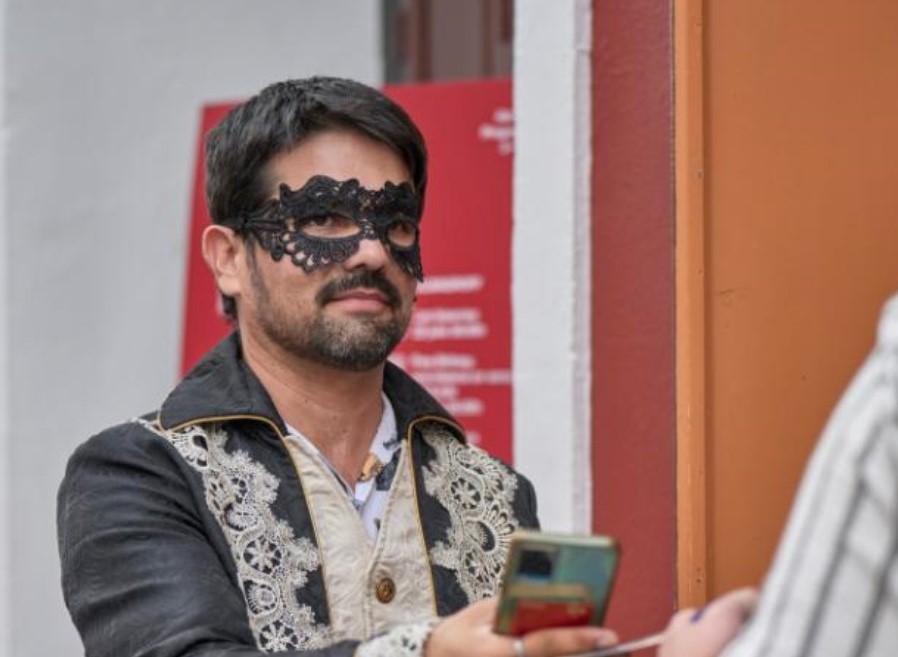 Hombre con antifaz negro y ropa decorada