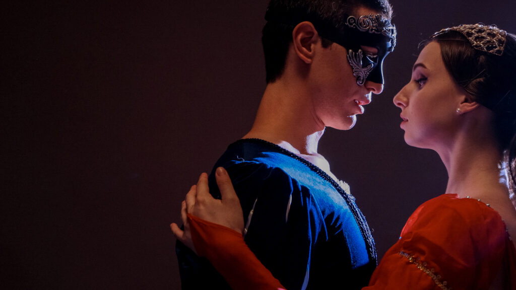 Pareja enmascarada en trajes medievales bailando