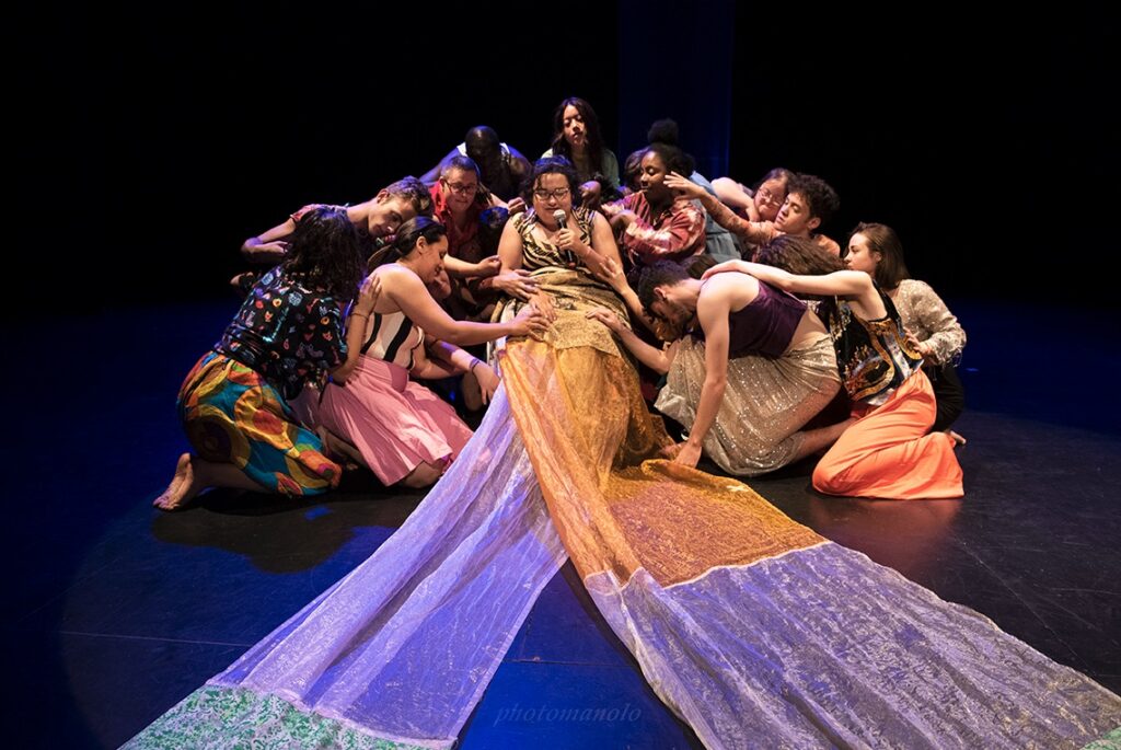 Grupo teatral en escena con tela colorida