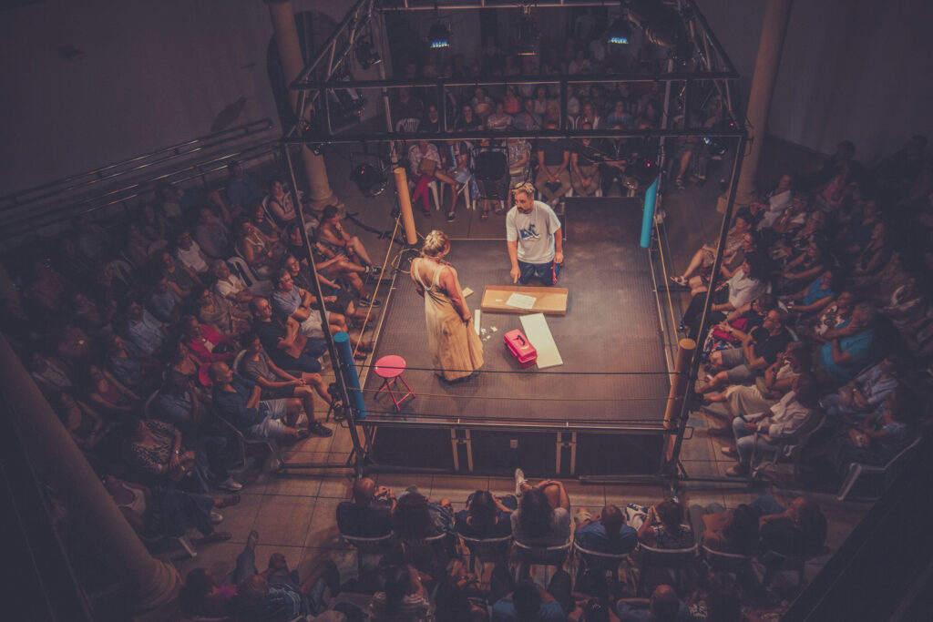 Escenario teatral rodeado de público asistente