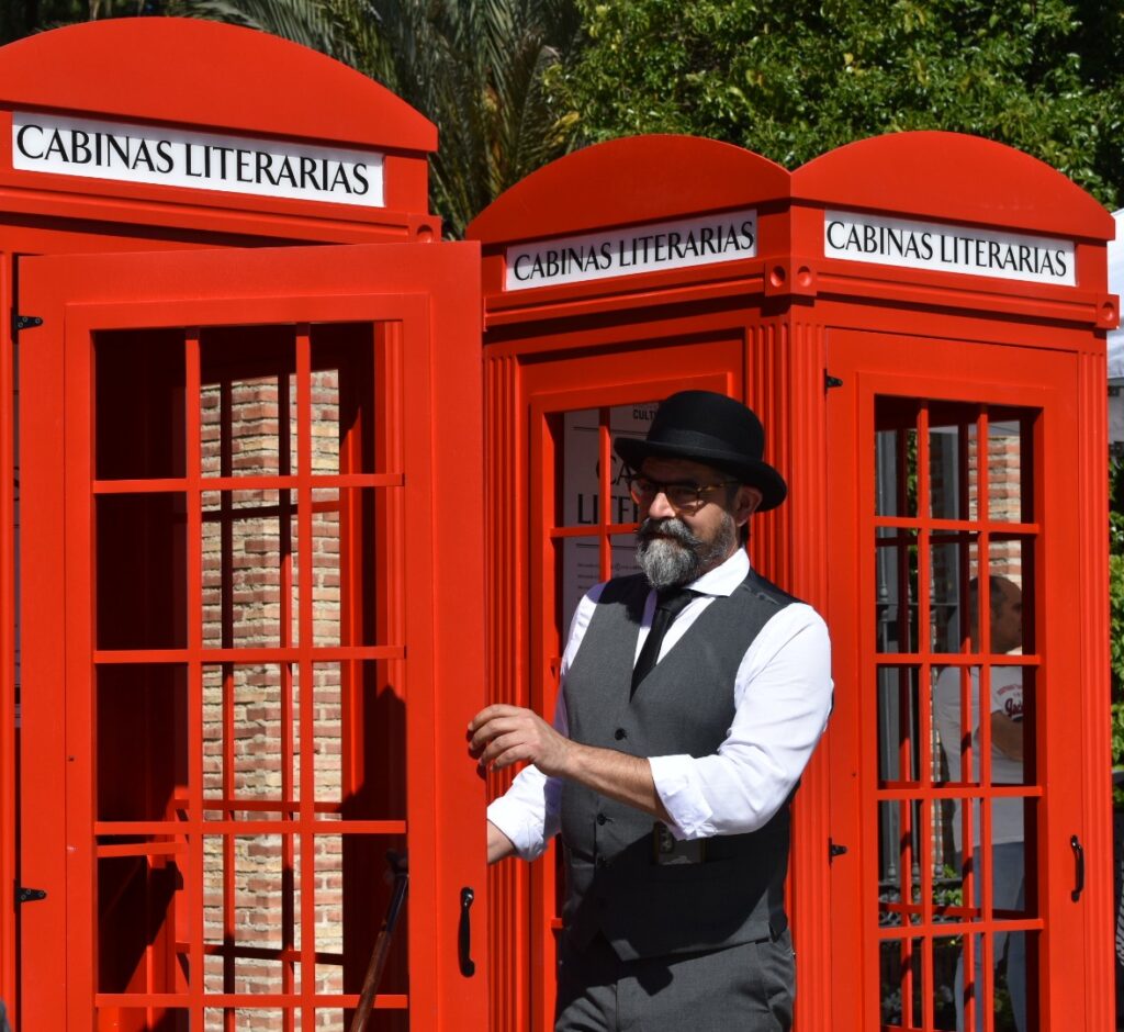 Hombre frente a cabinas literarias rojas