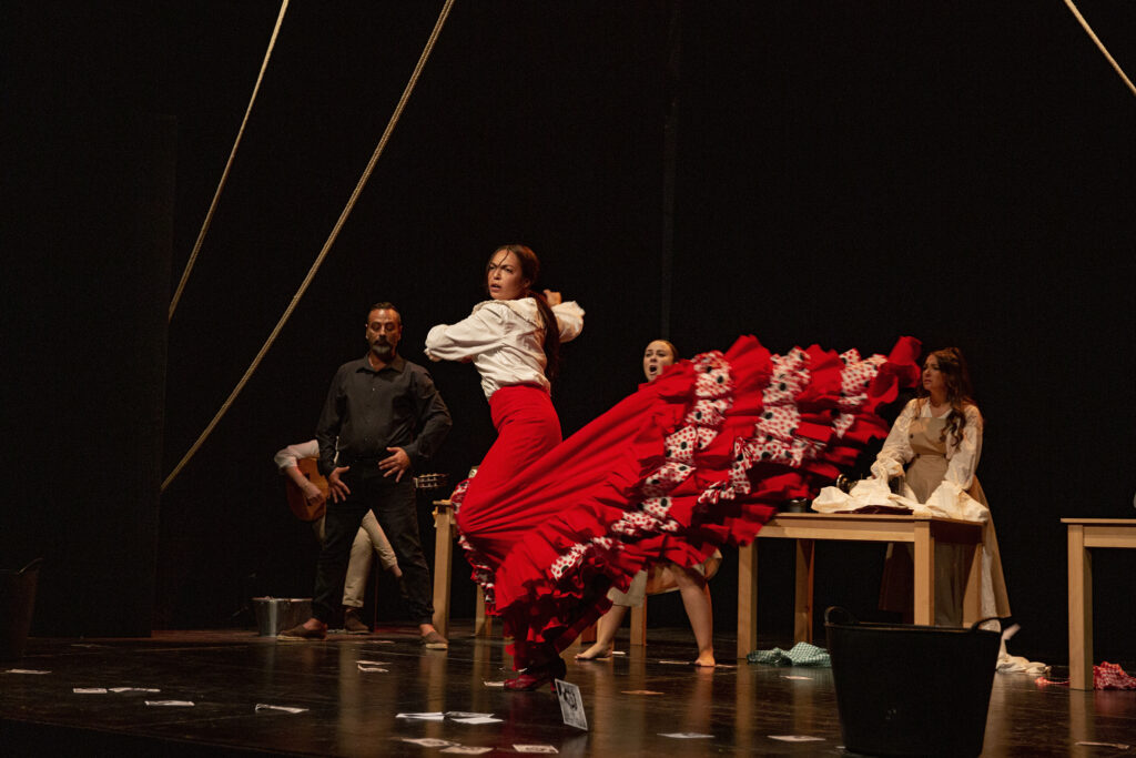 Bailarina flamenca con traje rojo en escenario.