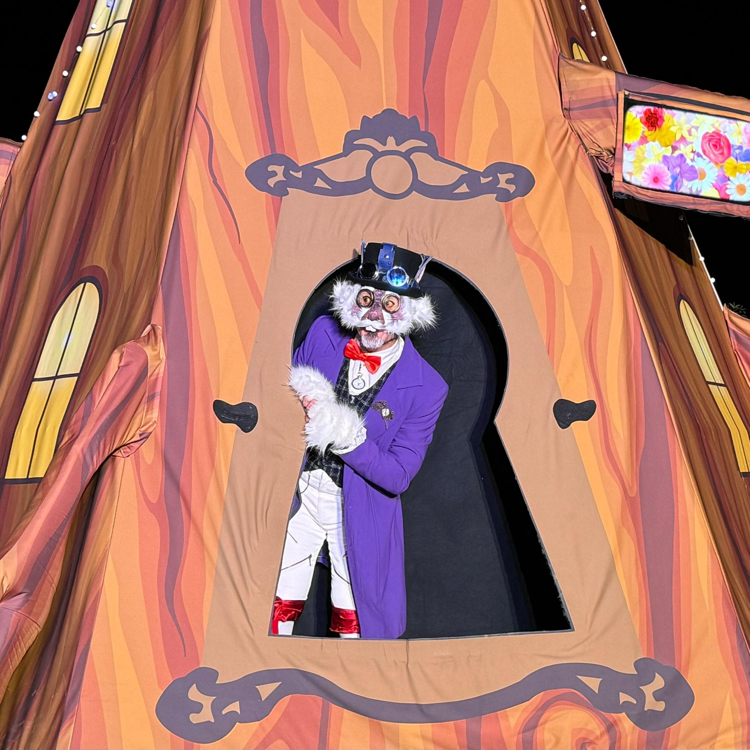 Personaje disfrazado en puerta decorativa colorida.