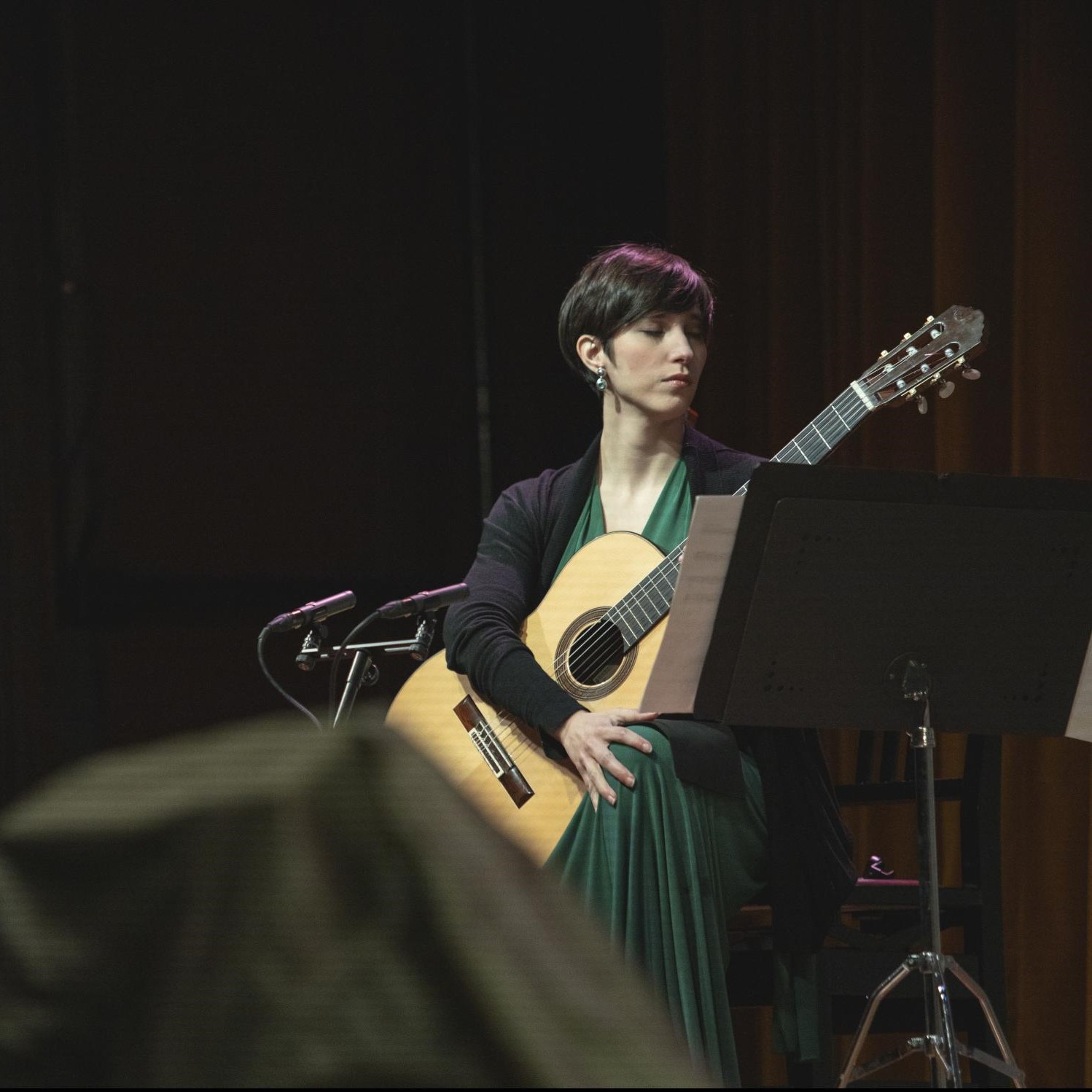 Persona tocando guitarra en escenario