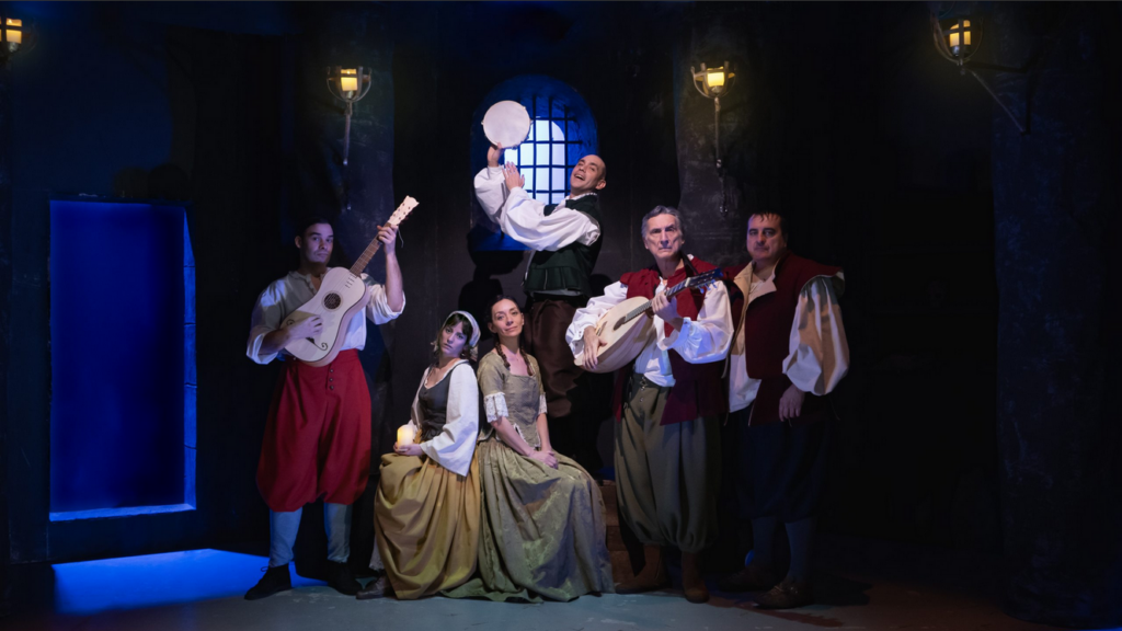 Grupo teatral medieval con instrumentos musicales.