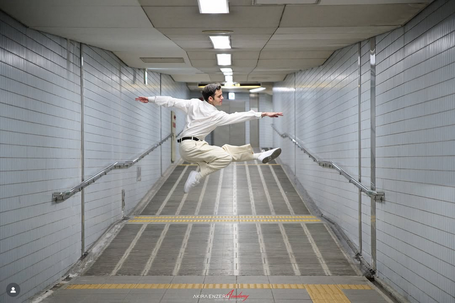 Hombre saltando en pasillo subterráneo.