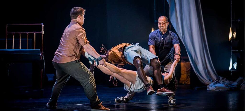 Artistas en escena haciendo acrobacias durante espectáculo.