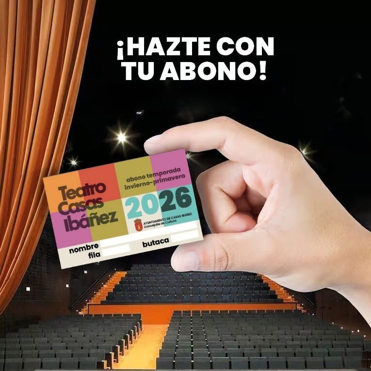 Mano sosteniendo abono del teatro en sala vacía.