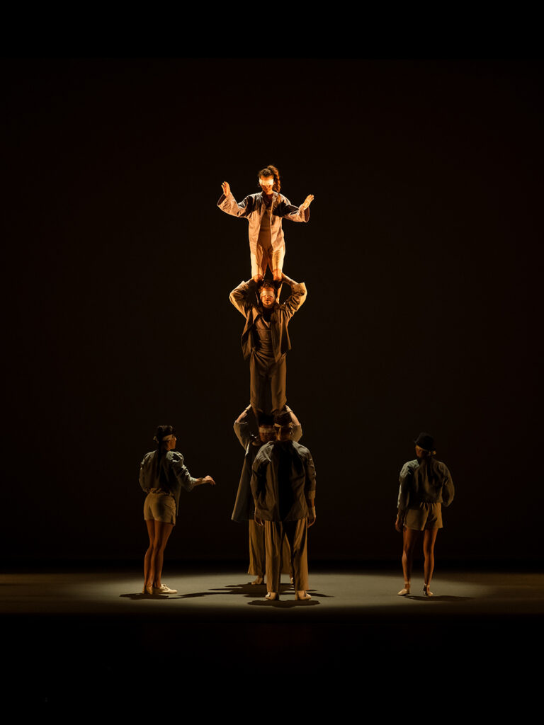 Artistas de circo en pirámide humana equilibrada.