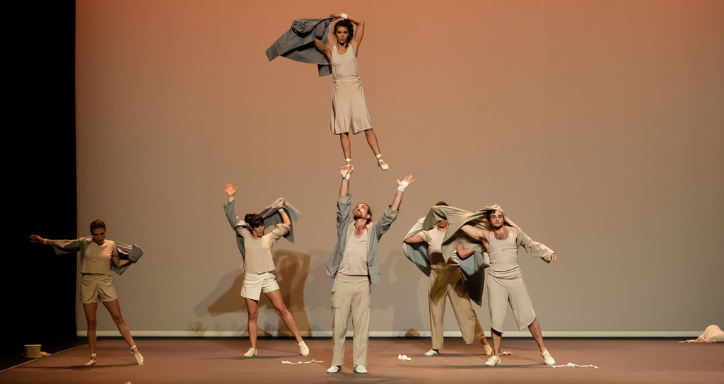 Grupo de artistas haciendo acrobacias en escenario.