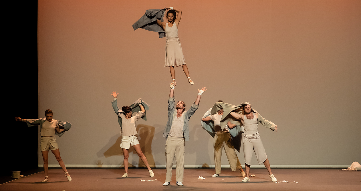Grupo de artistas haciendo acrobacias en escenario.