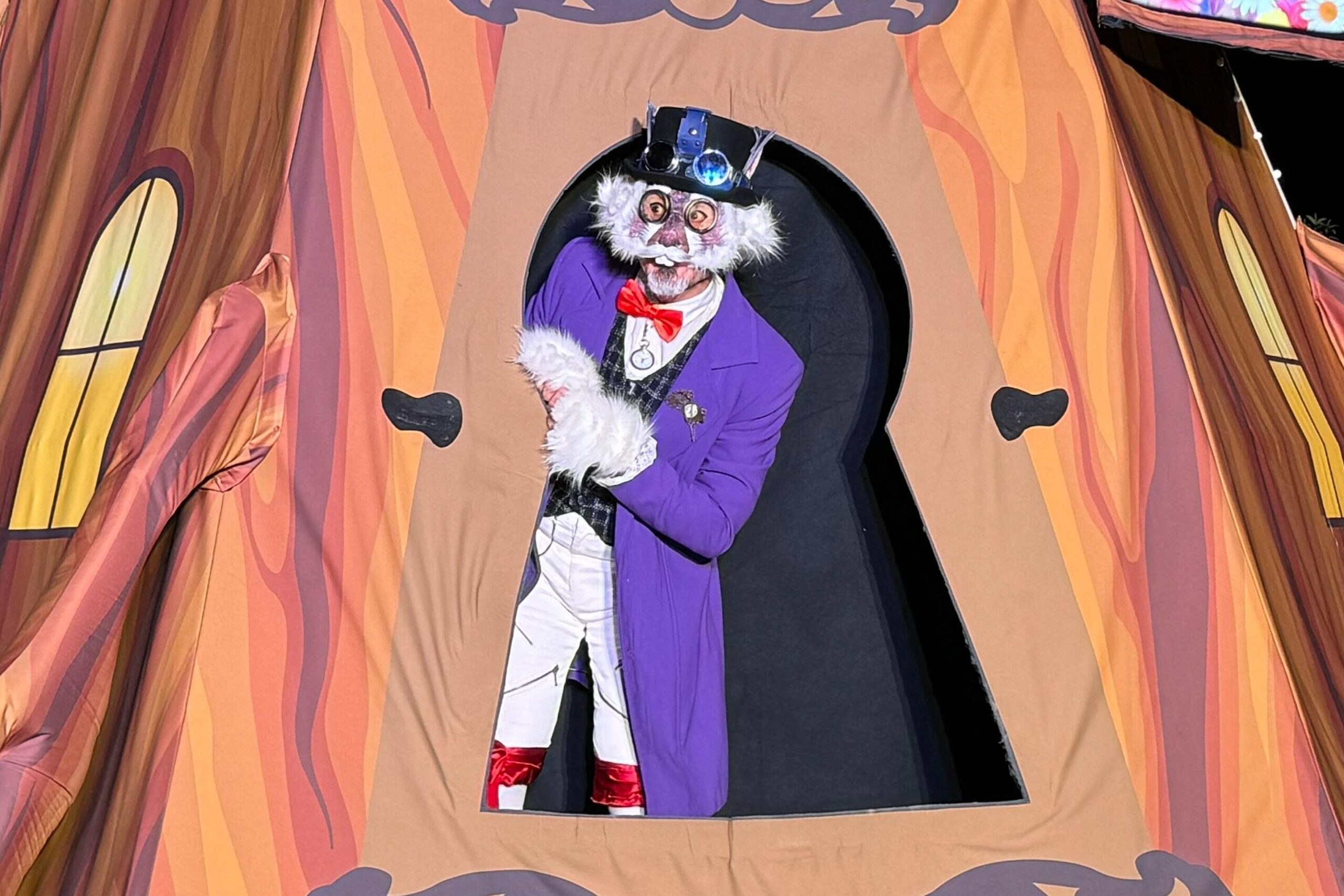 Personaje disfrazado en puerta decorativa colorida.