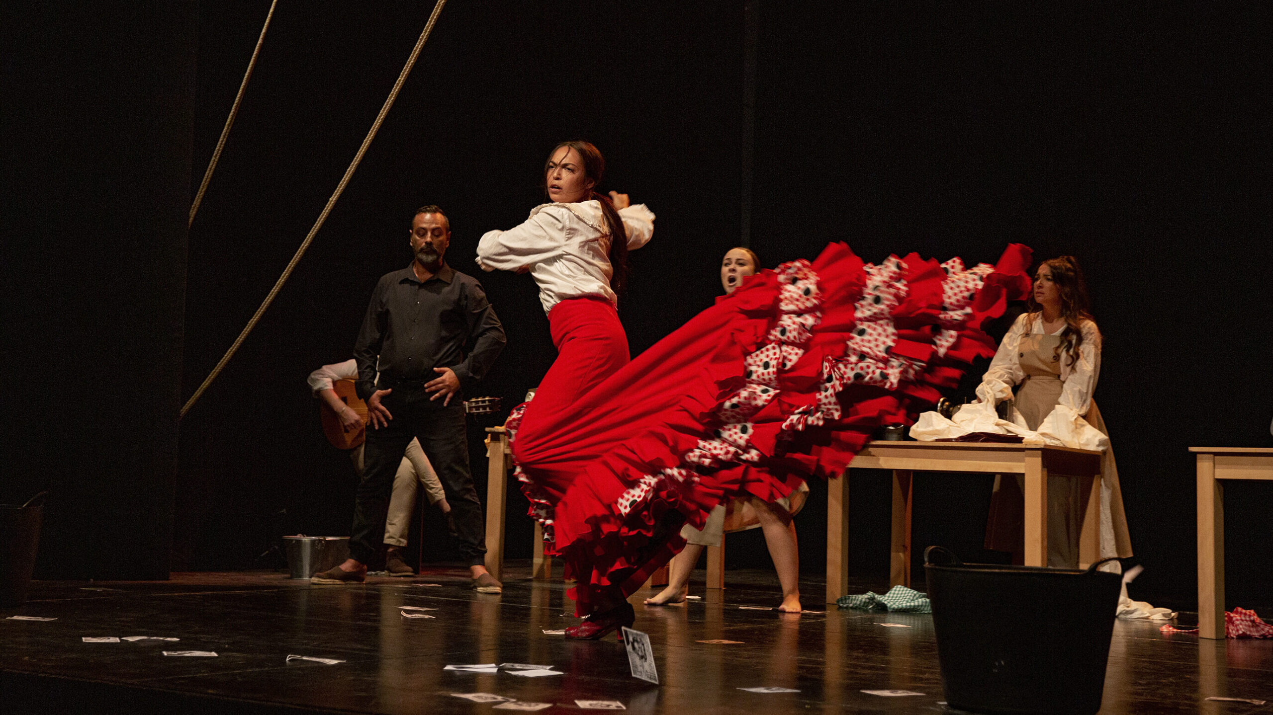 Bailarina flamenca con traje rojo en escenario.