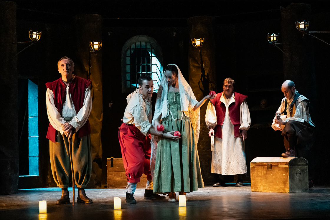 Escena teatral con cinco actores en el escenario.