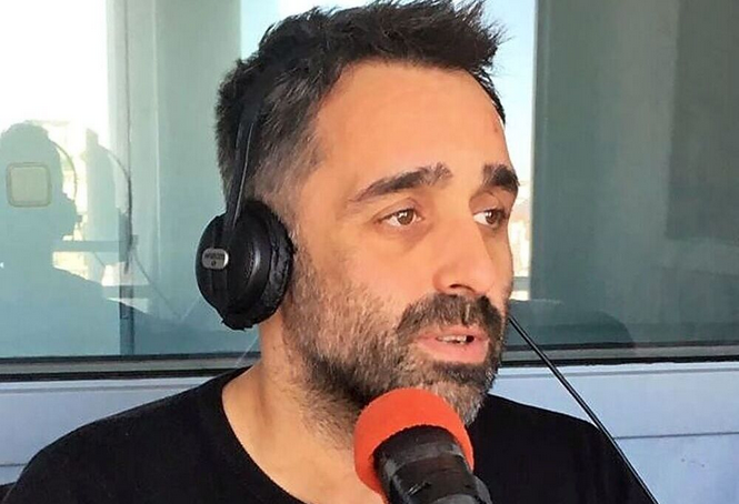 Hombre con auriculares hablando ante micrófono rojo