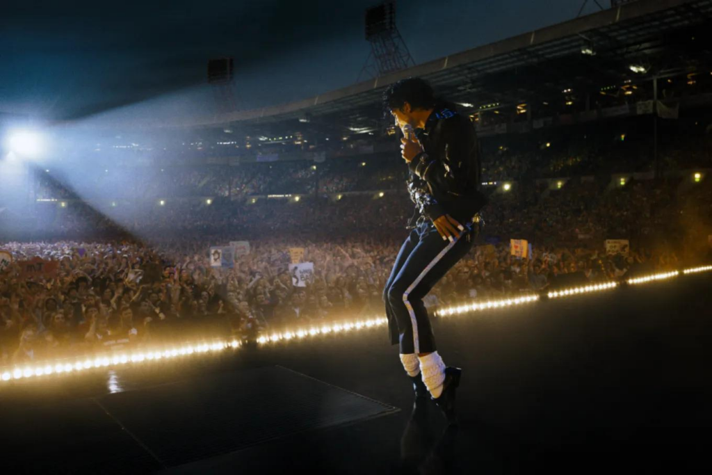 Cantante actuando ante multitud en estadio iluminado