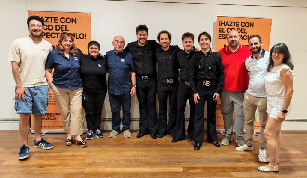 Grupo posando en evento musical con banners promocionales