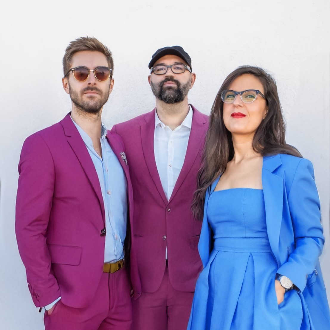 Tres personas con trajes coloridos posando
