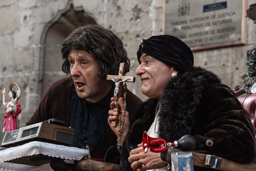 Dos personas con crucifijo y objetos religiosos antiguos
