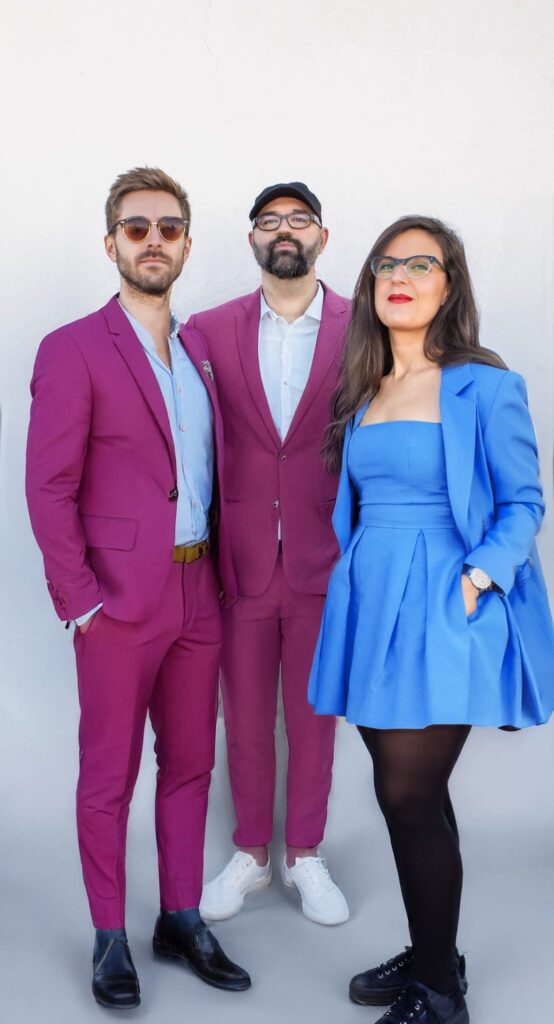 Tres personas con trajes coloridos posando