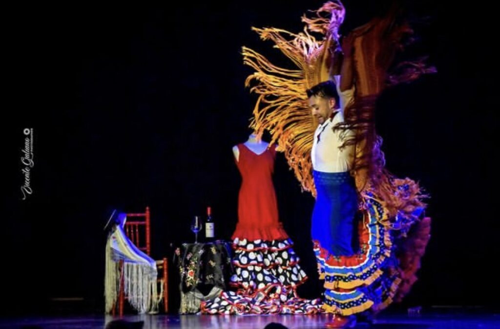 Bailarina de flamenco con vestido colorido en escenario