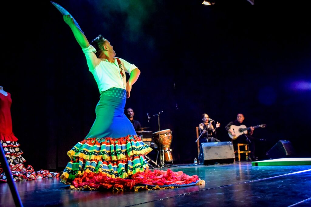 Bailarín de flamenco actuando en escenario con músicos