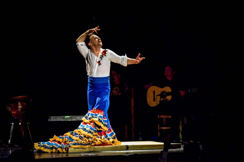 Bailaor de flamenco actuando en escenario oscuro