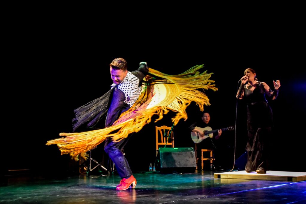 Bailaor flamenco con mantón en escenario