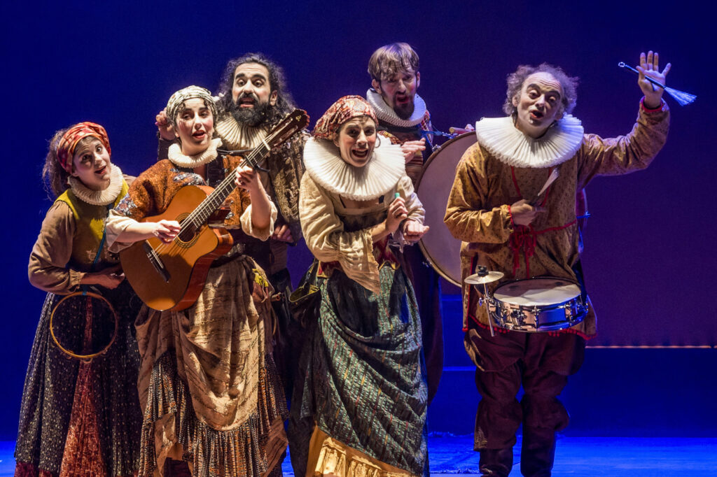 Cinco actores con vestuario histórico interpretan música en escena