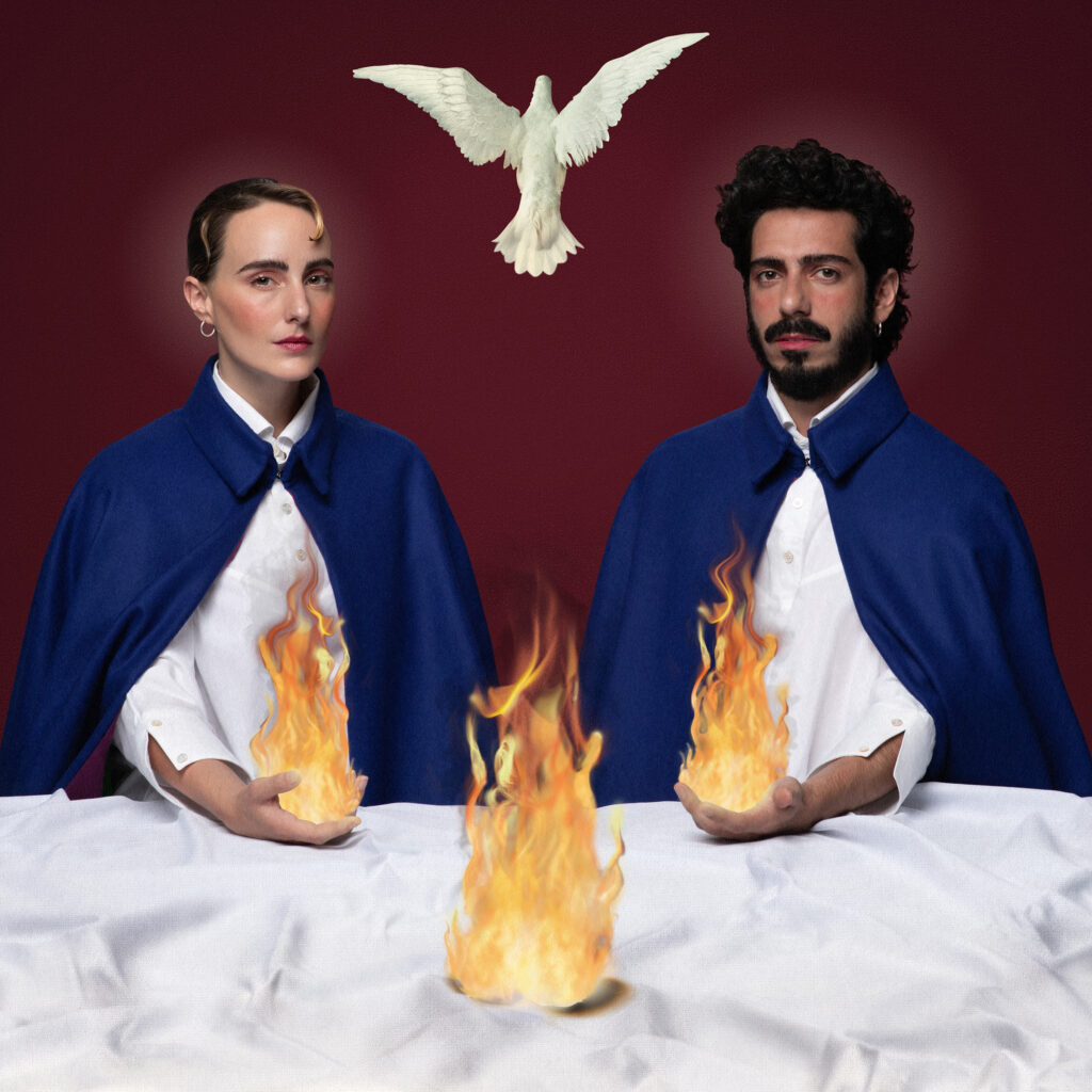 Dos personas con capas azules, fuego y una paloma blanca