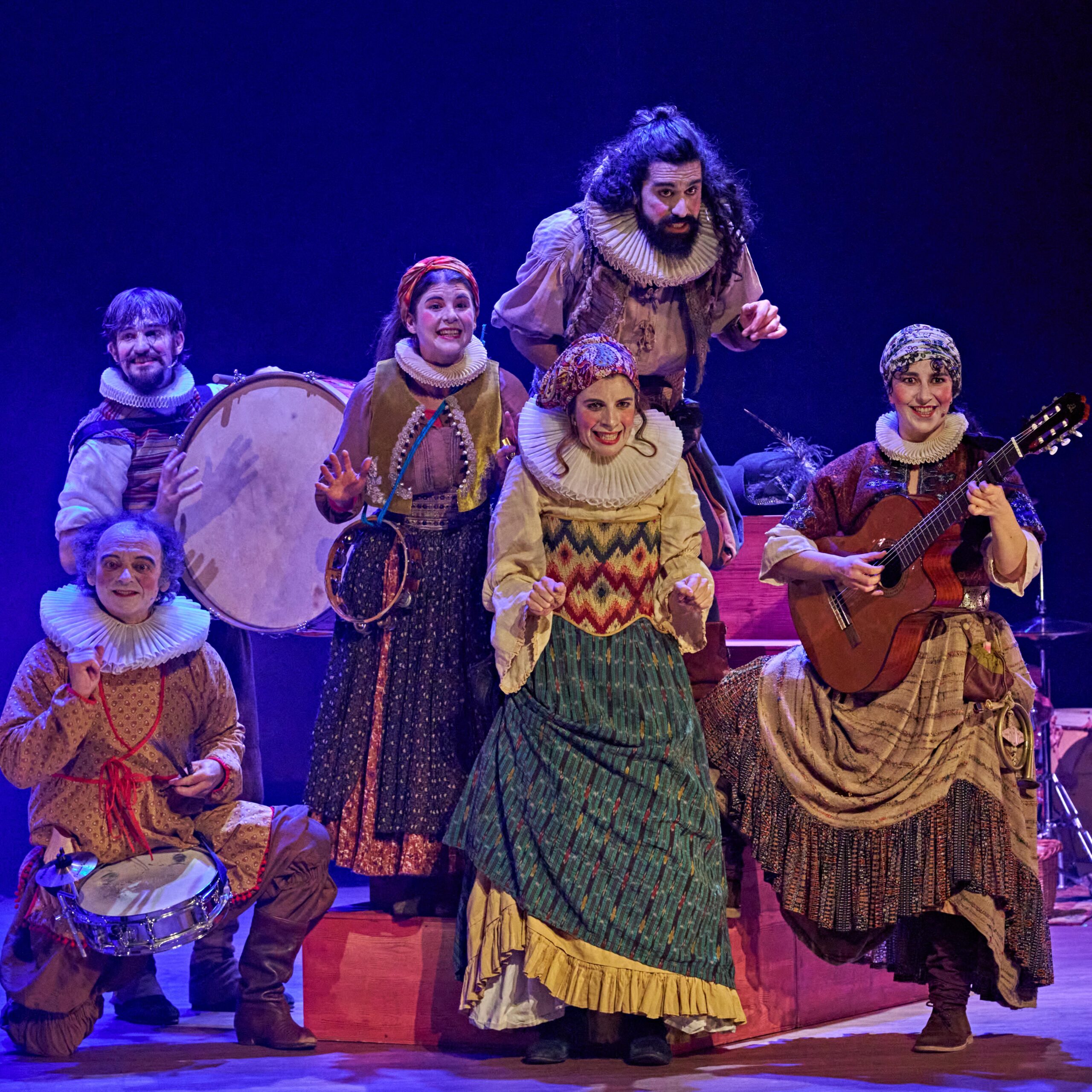 Músicos con trajes tradicionales tocan en escenario azul