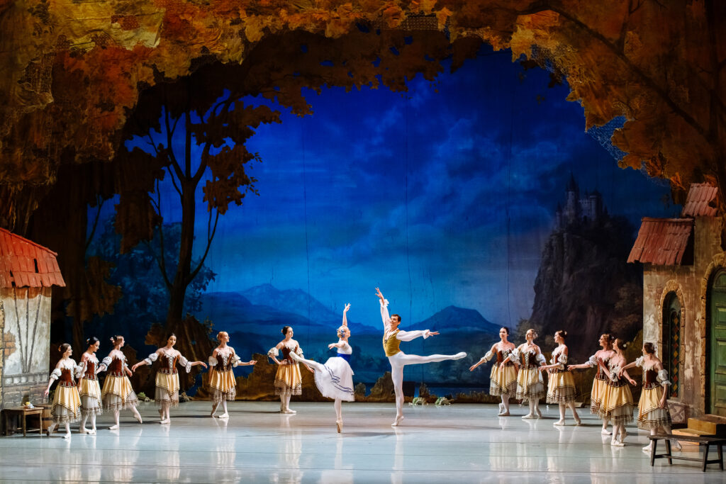 Bailarines interpretan ballet ante un castillo nocturno