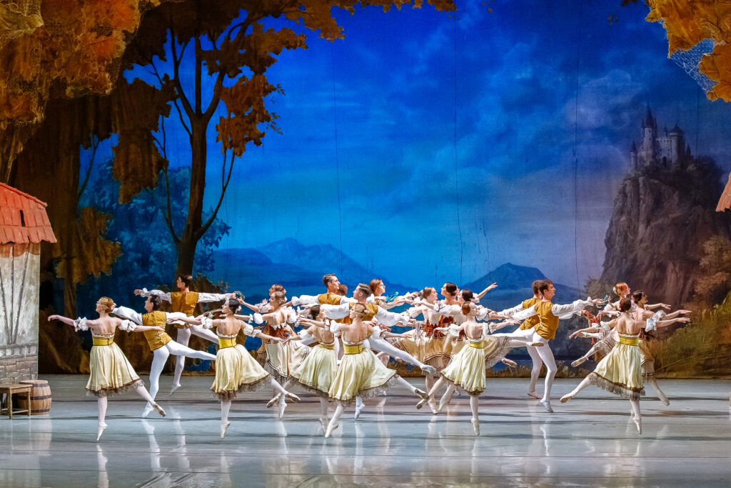Cuerpo de ballet bailando ante un castillo en escena