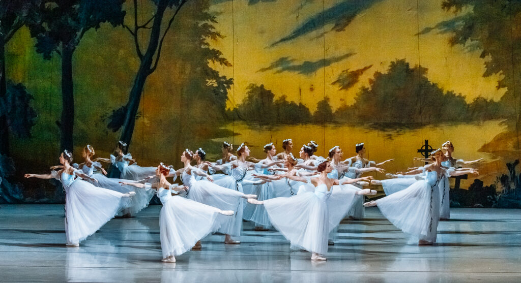 Cuerpo de ballet con vestidos blancos sobre un escenario