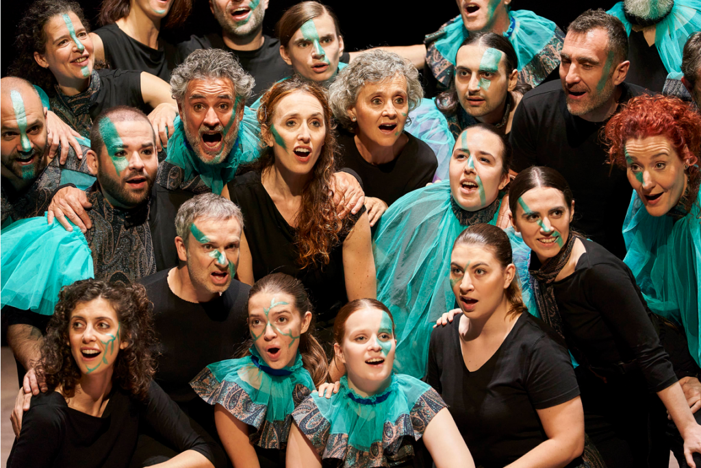 Coro teatral con maquillaje turquesa y vestuario negro