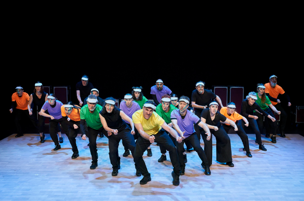 Grupo de bailarines con camisetas coloridas en escenario