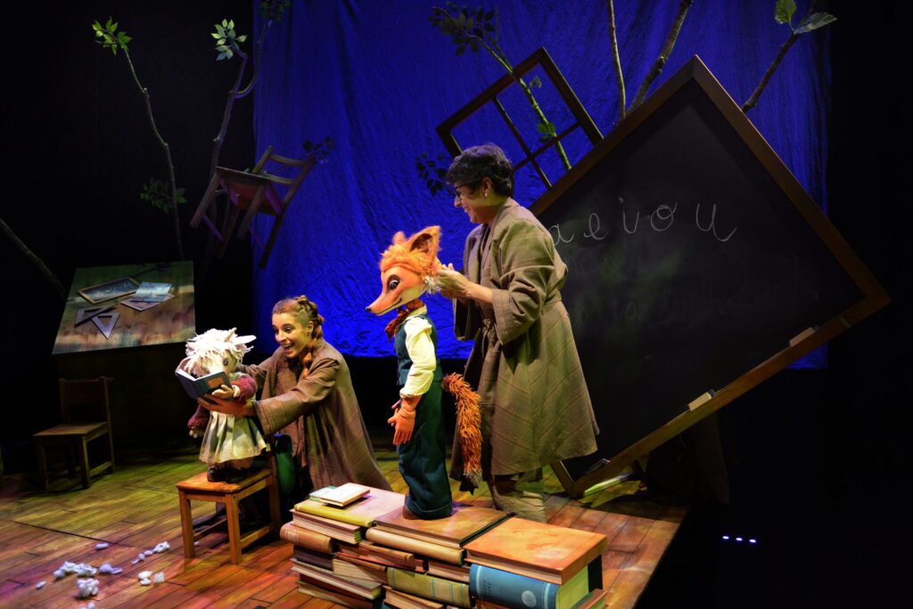 Actrices con marionetas en un escenario escolar