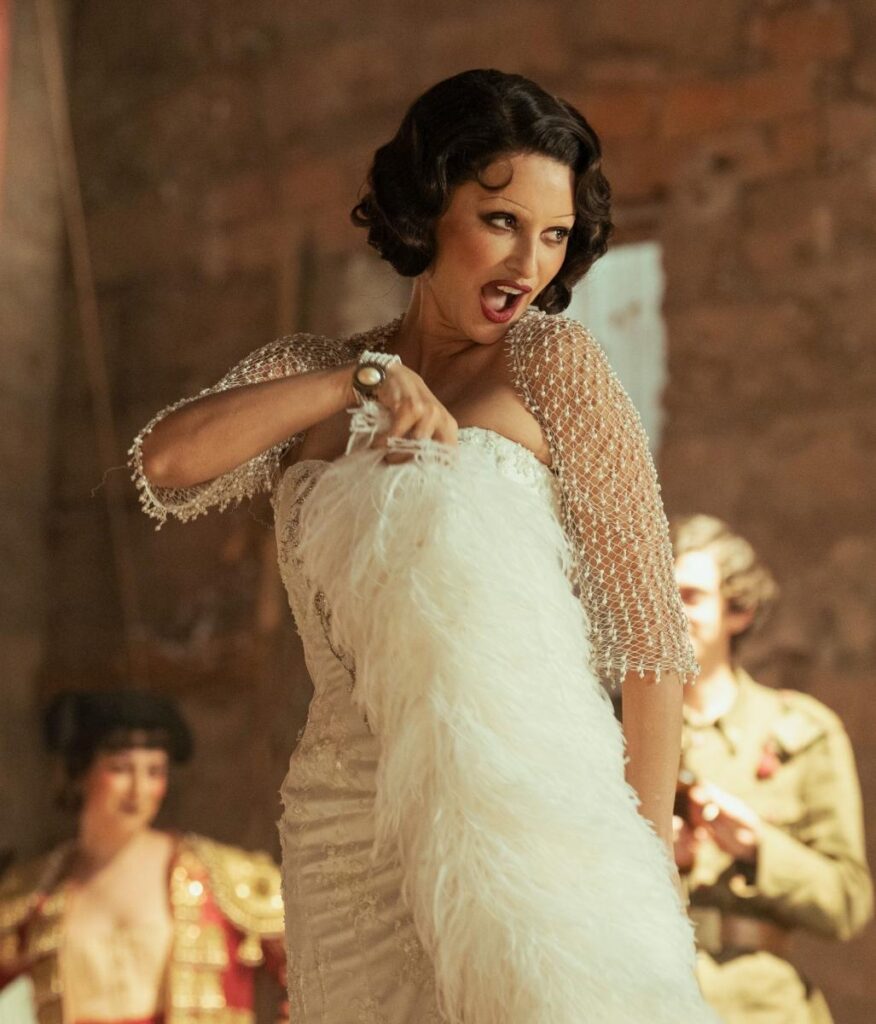 Artista de cabaré con vestido blanco y estola de plumas